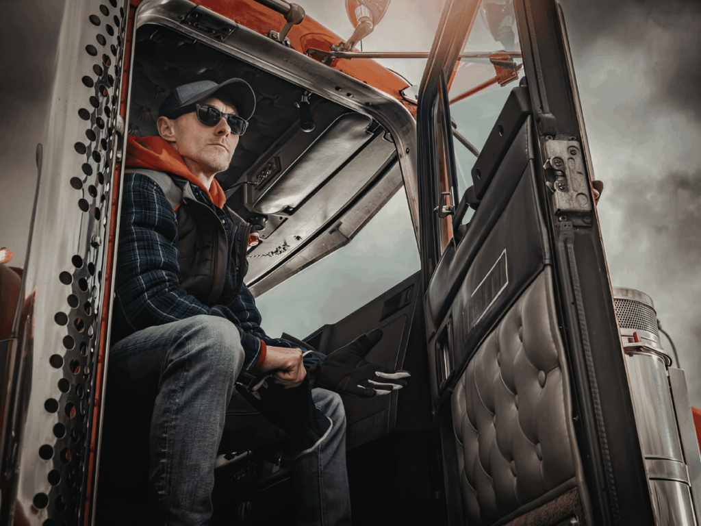 a tramping hgv driver sits in his cab on a long-distance hgv driving route